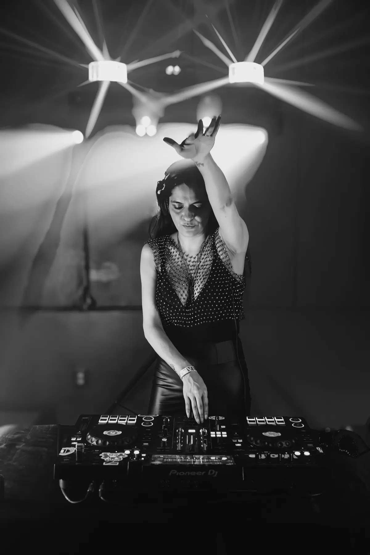 Susie Otto performing under sharp beams of club lighting