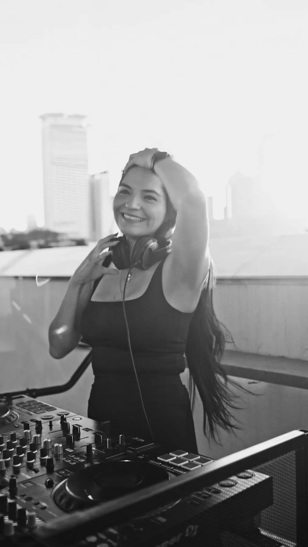 Susie Otto smiling during a bright daytime rooftop performance